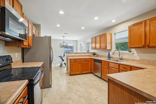 7230 Sunrise Lk, San Antonio, TX 78244 - kitchen featuring appliances with stainless steel finishes, a sink, a peninsula, recessed lighting, and light countertops