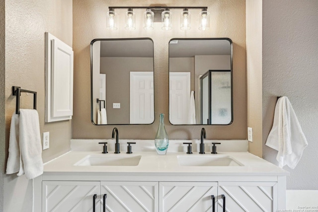 7230 Sunrise Lk, San Antonio, TX 78244 - bathroom featuring a textured wall, double vanity, and a shower stall