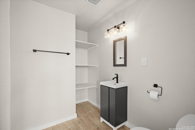 402 Twin Elm, Canyon Lake, TX 78133 - bathroom featuring wood finished floors, toilet, vanity, and baseboards