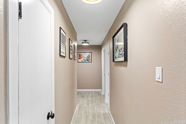 hall with baseboards and wood finish floors