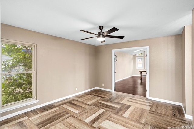 empty room featuring plenty of natural light, baseboards, and a ceiling fan