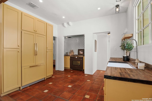 241 W Elsmere, San Antonio, TX 78212 - kitchen with black gas stove, a sink, cream cabinetry, recessed lighting, and wooden counters