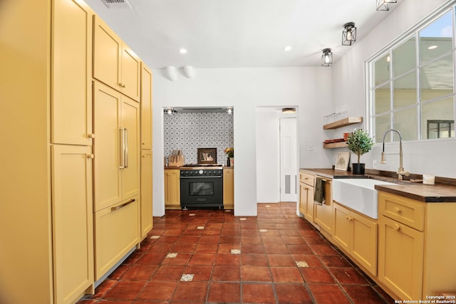 241 W Elsmere, San Antonio, TX 78212 - kitchen featuring range with gas stovetop, a sink, open shelves, cream cabinetry, and dark tile patterned flooring