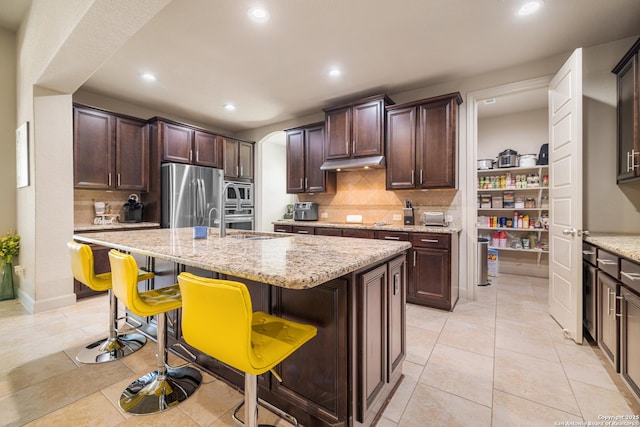 4438 Saddle Spur, San Antonio, TX 78253 - kitchen with stainless steel appliances, a kitchen bar, recessed lighting, tasteful backsplash, and dark brown cabinetry