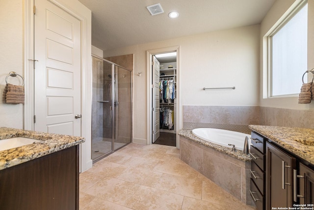 4438 Saddle Spur, San Antonio, TX 78253 - bathroom featuring a stall shower, vanity, a garden tub, a walk in closet, and tile patterned flooring