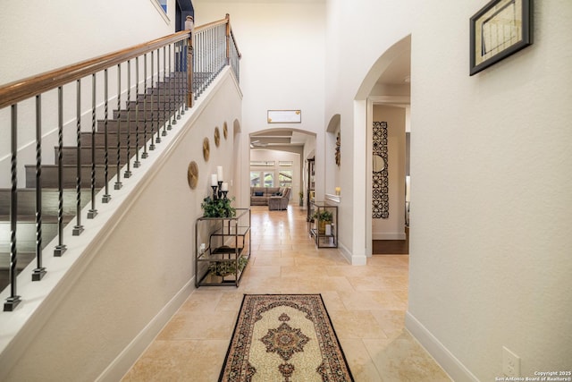 4438 Saddle Spur, San Antonio, TX 78253 - entrance foyer featuring arched walkways, a high ceiling, baseboards, and stairway
