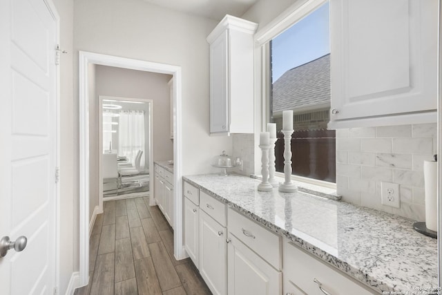 8823 Hideout, San Antonio, TX 78254 - kitchen with white cabinets, tasteful backsplash, dark wood-style floors, and light stone counters
