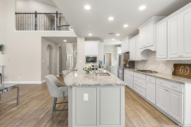 8823 Hideout, San Antonio, TX 78254 - kitchen featuring a sink, stainless steel appliances, light wood finished floors, white cabinets, and recessed lighting