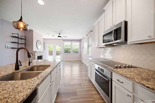 2060 Oedipus, San Antonio, TX 78245 - kitchen with appliances with stainless steel finishes, a sink, decorative backsplash, a ceiling fan, and white cabinets