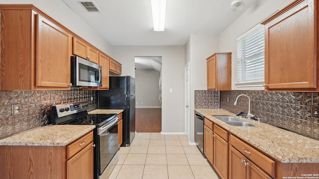 2253 Hidden Mdw, New Braunfels, TX 78130 - kitchen with appliances with stainless steel finishes, a sink, light tile patterned floors, and tasteful backsplash