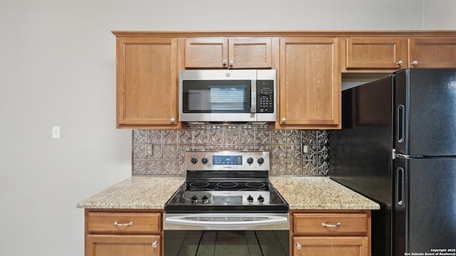 2253 Hidden Mdw, New Braunfels, TX 78130 - kitchen featuring appliances with stainless steel finishes, backsplash, light stone counters, and brown cabinets