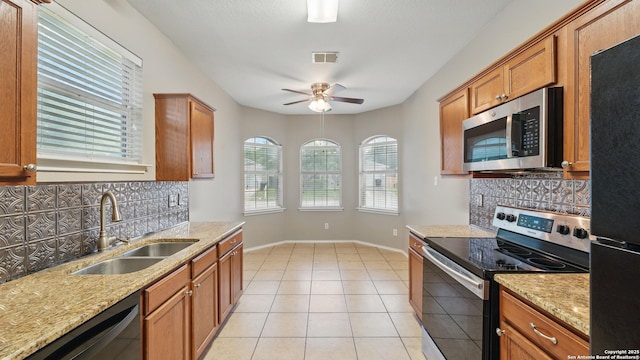 2253 Hidden Mdw, New Braunfels, TX 78130 - kitchen with stainless steel appliances, a sink, tasteful backsplash, and brown cabinetry
