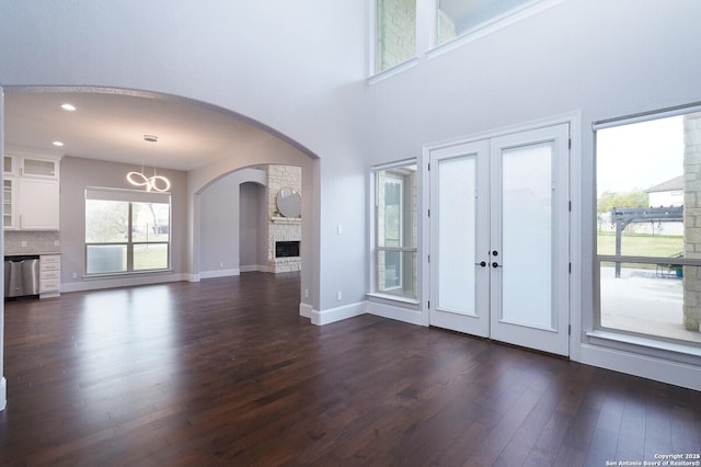 25203 Spider Rock, Boerne, TX 78006 - unfurnished living room with dark wood-type flooring, french doors, a fireplace, a chandelier, and baseboards