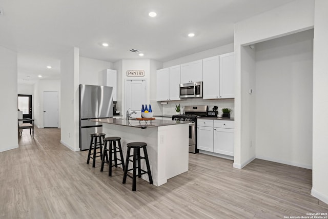 6718 Carlton Crst, San Antonio, TX 78253 - kitchen with appliances with stainless steel finishes, dark countertops, a kitchen bar, tasteful backsplash, and recessed lighting