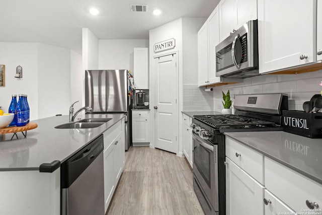 6718 Carlton Crst, San Antonio, TX 78253 - kitchen with appliances with stainless steel finishes, a sink, light wood-style flooring, white cabinets, and recessed lighting