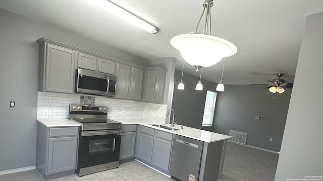 6711 Dragon Tooth, San Antonio, TX 78242 - kitchen featuring appliances with stainless steel finishes, gray cabinets, a sink, and a peninsula