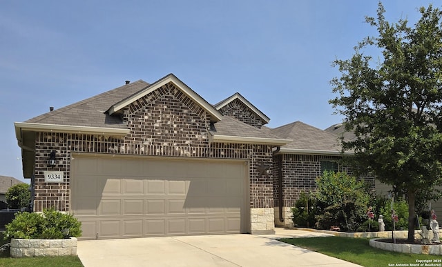 9334 Sundrop, San Antonio, TX 78254 - french country home featuring a garage, brick siding, roof with shingles, concrete driveway, and stone siding