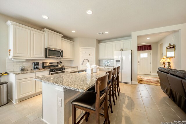 9334 Sundrop, San Antonio, TX 78254 - kitchen featuring appliances with stainless steel finishes, a sink, tasteful backsplash, light stone counters, and recessed lighting