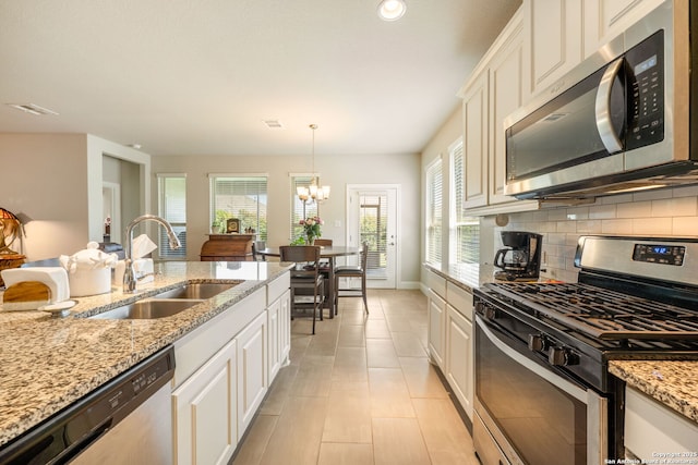 9334 Sundrop, San Antonio, TX 78254 - kitchen with stainless steel appliances, a sink, backsplash, a chandelier, and healthy amount of natural light