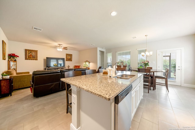 9334 Sundrop, San Antonio, TX 78254 - kitchen featuring dishwasher, a sink, light stone counters, a kitchen island with sink, and a chandelier