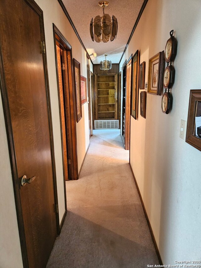 109 Cueva, Hollywood Park, TX 78232 - corridor featuring a chandelier, light colored carpet, crown molding, a textured ceiling, and baseboards