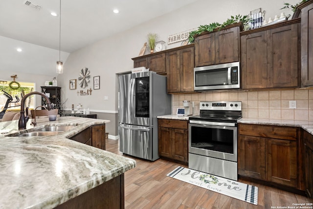 184 Great Oaks Ln, Vernia, TX 78121 - kitchen featuring stainless steel appliances, a sink, vaulted ceiling, decorative backsplash, and light wood finished floors