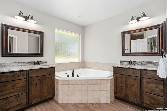184 Great Oaks Ln, Vernia, TX 78121 - full bath featuring a garden tub, two vanities, and wood finished floors