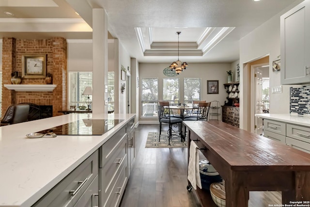 573 Mountain Oaks Dr, Canyon Lake, TX 78133 - kitchen featuring black electric stovetop, butcher block counters, healthy amount of natural light, a tray ceiling, and ornamental molding