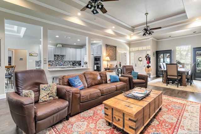 573 Mountain Oaks Dr, Canyon Lake, TX 78133 - living room with ceiling fan, a raised ceiling, light wood finished floors, baseboards, and crown molding