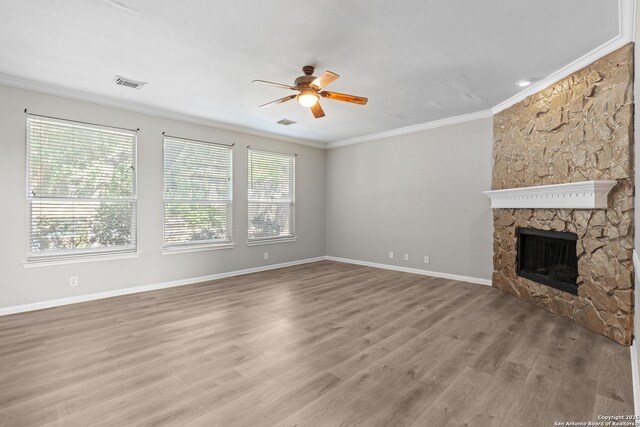 25233 Battle Lk, San Antonio, TX 78260 - unfurnished living room with a ceiling fan, ornamental molding, wood finished floors, baseboards, and a stone fireplace