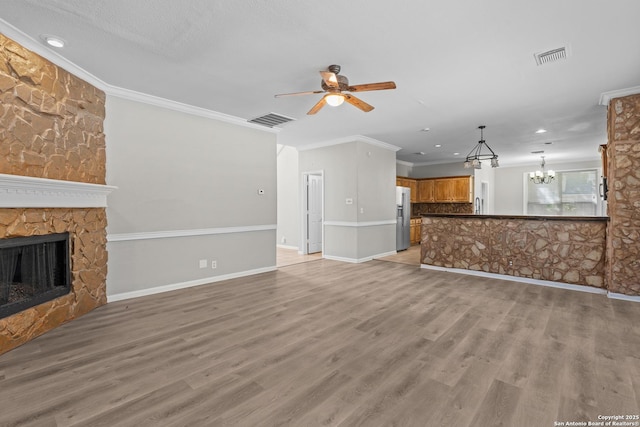 25233 Battle Lk, San Antonio, TX 78260 - unfurnished living room featuring a chandelier, a ceiling fan, a fireplace, crown molding, and recessed lighting