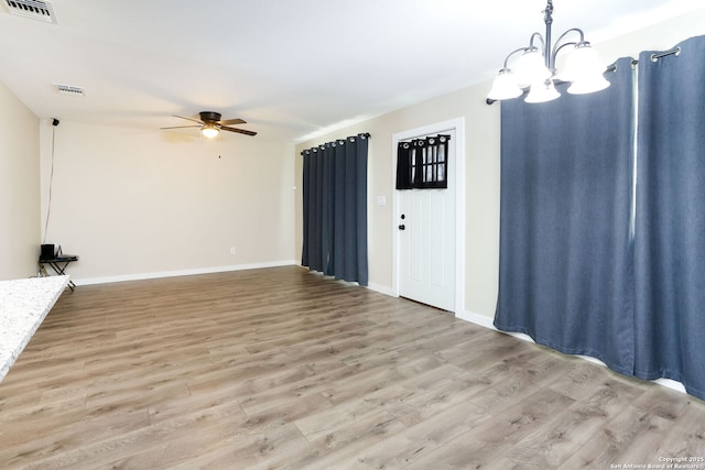 239 Surrey, San Antonio, TX 78225 - unfurnished living room featuring a chandelier, a ceiling fan, light wood-style floors, and baseboards