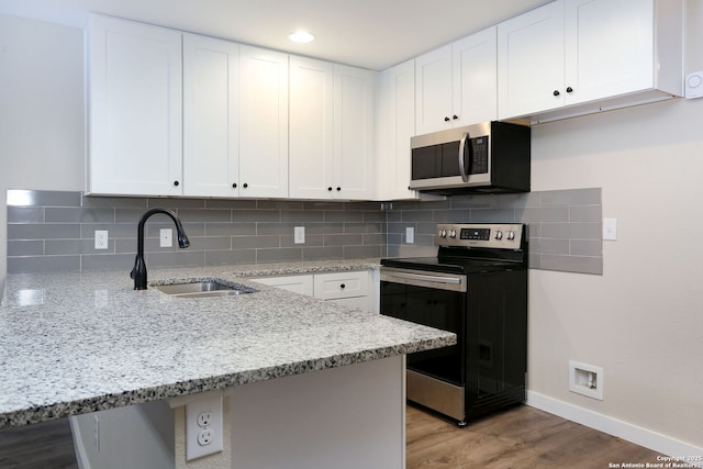 239 Surrey, San Antonio, TX 78225 - kitchen with stainless steel appliances, a sink, a peninsula, and light stone counters