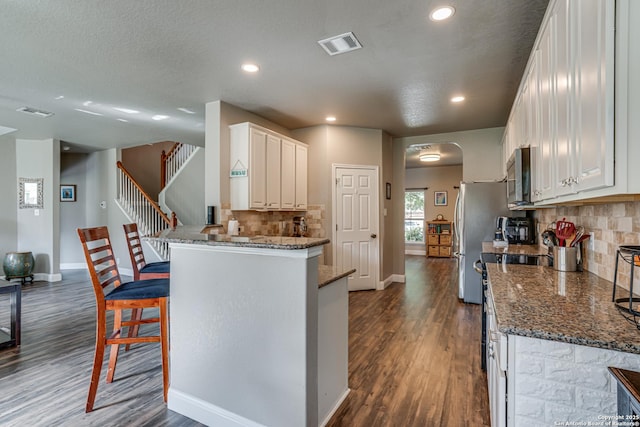 214 Ridge Blf, Cibolo, TX 78108 - kitchen featuring appliances with stainless steel finishes, baseboards, dark wood-type flooring, white cabinetry, and tasteful backsplash