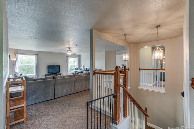 214 Ridge Blf, Cibolo, TX 78108 - living area featuring a textured ceiling, ceiling fan, carpet flooring, and arched walkways