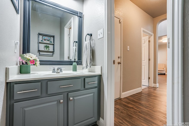 214 Ridge Blf, Cibolo, TX 78108 - bathroom featuring wood finished floors, vanity, baseboards, and a textured wall