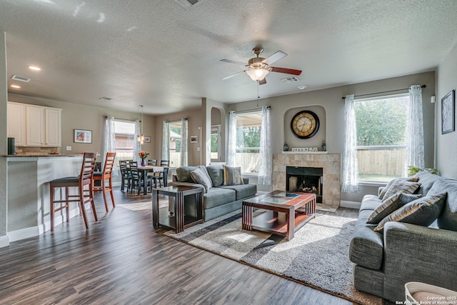 214 Ridge Blf, Cibolo, TX 78108 - living area featuring a ceiling fan, wood finished floors, a textured ceiling, baseboards, and a fireplace