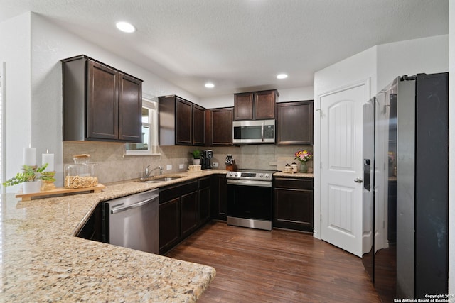 184 Jolie Cir, Boerne, TX 78015 - kitchen featuring stainless steel appliances, a sink, dark brown cabinetry, dark wood finished floors, and decorative backsplash
