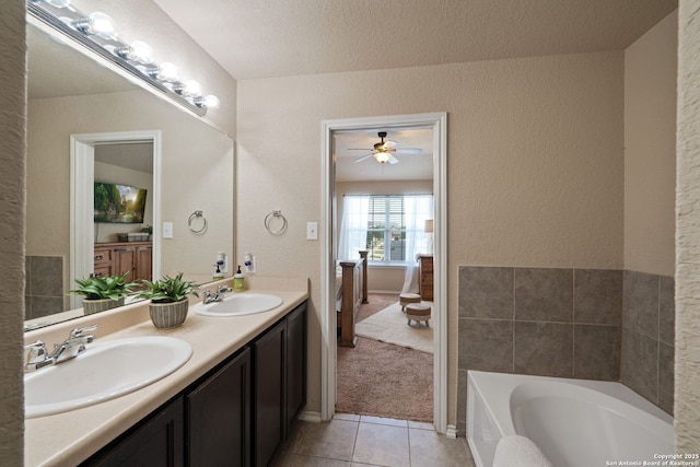 184 Jolie Cir, Boerne, TX 78015 - bathroom featuring tile patterned flooring, ceiling fan, a bath, double vanity, and a textured wall