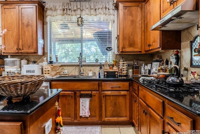 3351 Highline Trl, San Antonio, TX 78261 - kitchen featuring under cabinet range hood, a sink, decorative backsplash, and brown cabinets