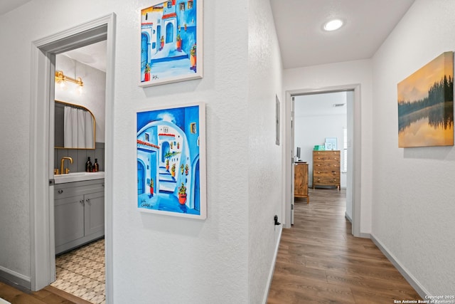 351 Barbara, San Antonio, TX 78216 - corridor featuring wood finished floors, a textured wall, baseboards, a sink, and recessed lighting
