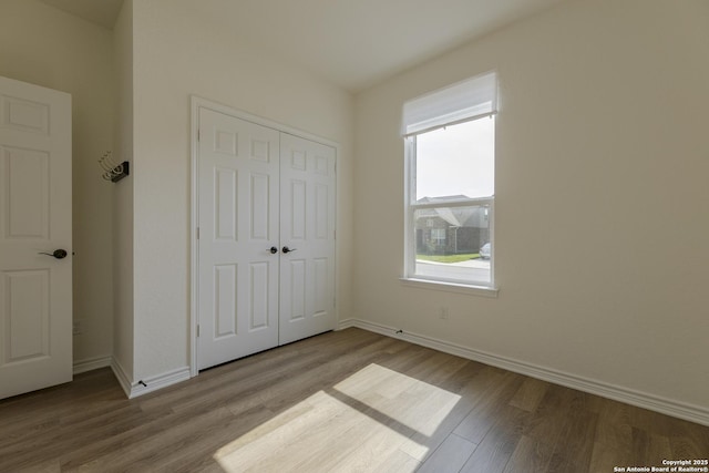22363 Escalante Run, San Antonio, TX 78261 - unfurnished bedroom featuring wood finished floors, a closet, and baseboards