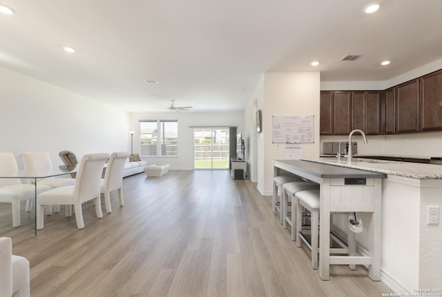 22363 Escalante Run, San Antonio, TX 78261 - kitchen featuring dark brown cabinetry, light wood finished floors, open floor plan, ceiling fan, and recessed lighting