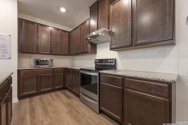 22363 Escalante Run, San Antonio, TX 78261 - kitchen featuring stainless steel appliances, under cabinet range hood, light wood-style flooring, tasteful backsplash, and dark brown cabinets