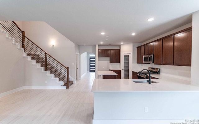 13226 Blue Flame, San Antonio, TX 78245 - kitchen with appliances with stainless steel finishes, arched walkways, a sink, dark brown cabinets, and recessed lighting