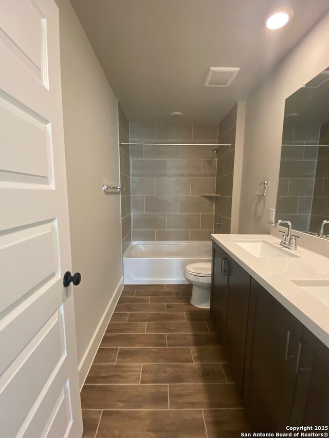 11111 Carlyle Spgs, Live Oak, TX 78233 - bathroom featuring wood tiled floors, toilet, double vanity, shower / washtub combination, and recessed lighting