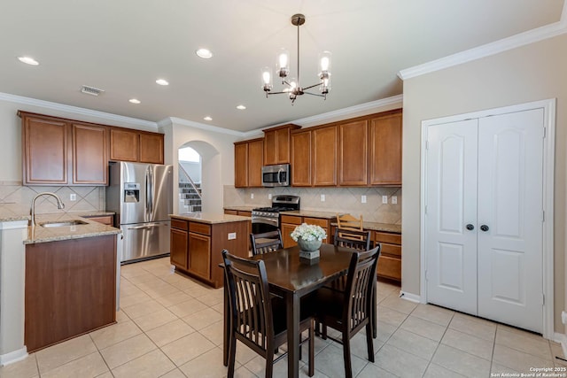 23022 Airedale Ln, San Antonio, TX 78260 - kitchen with appliances with stainless steel finishes, arched walkways, brown cabinetry, a sink, and light tile patterned floors