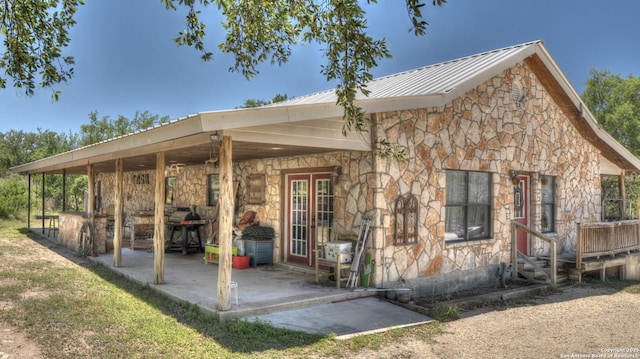121 David Rankin Rd, Leakey, TX 78873 - rear view of property featuring stone siding, metal roof, and a patio area