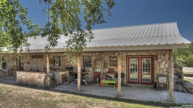 121 David Rankin Rd, Leakey, TX 78873 - rear view of property featuring stone siding, metal roof, and a patio area