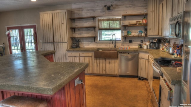 121 David Rankin Rd, Leakey, TX 78873 - kitchen with stainless steel appliances, open shelves, a sink, dark countertops, and light carpet